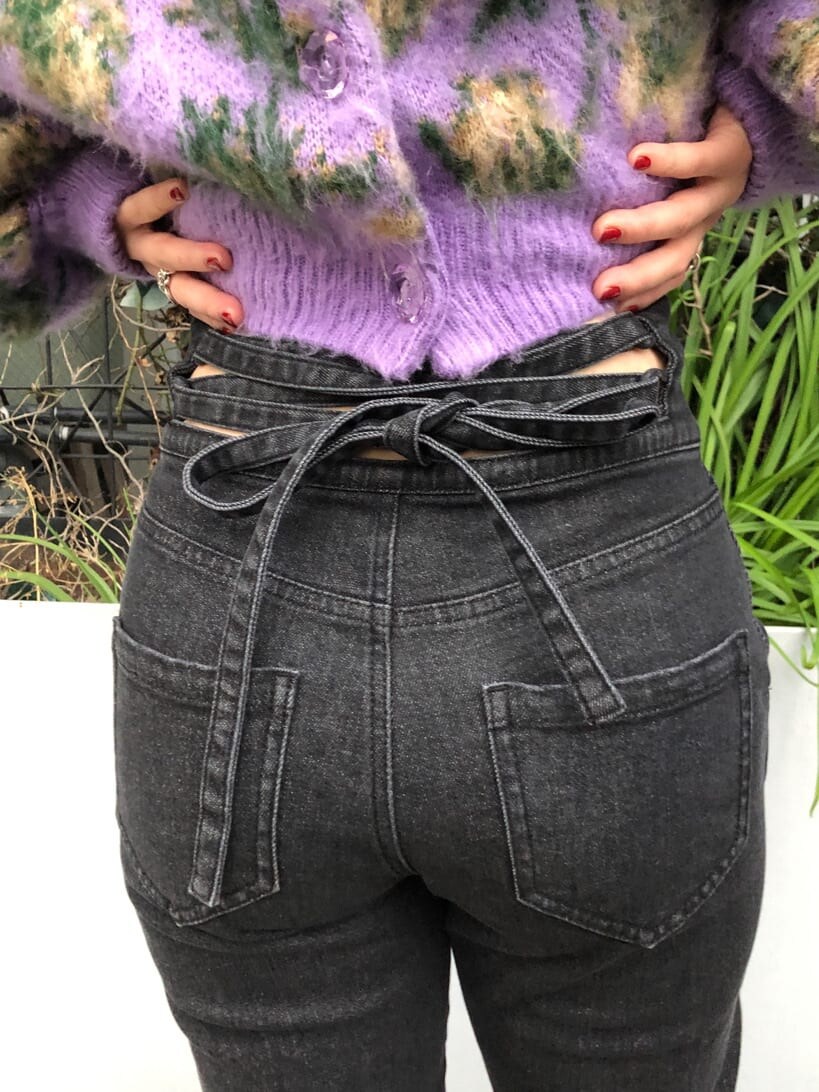 ブラック系のデニムパンツ、ブラック系のデニムジャケット、パープル系のカーディガン/ボレロを着用したレディースの冬コーディネートの8枚目の写真