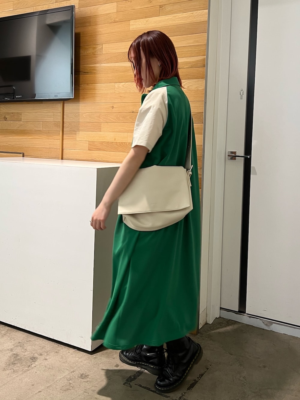 ホワイト系のタンクトップ、グリーン系のワンピース、ホワイト系のメッセンジャーバッグを着用したレディースの春コーディネートの3枚目の写真