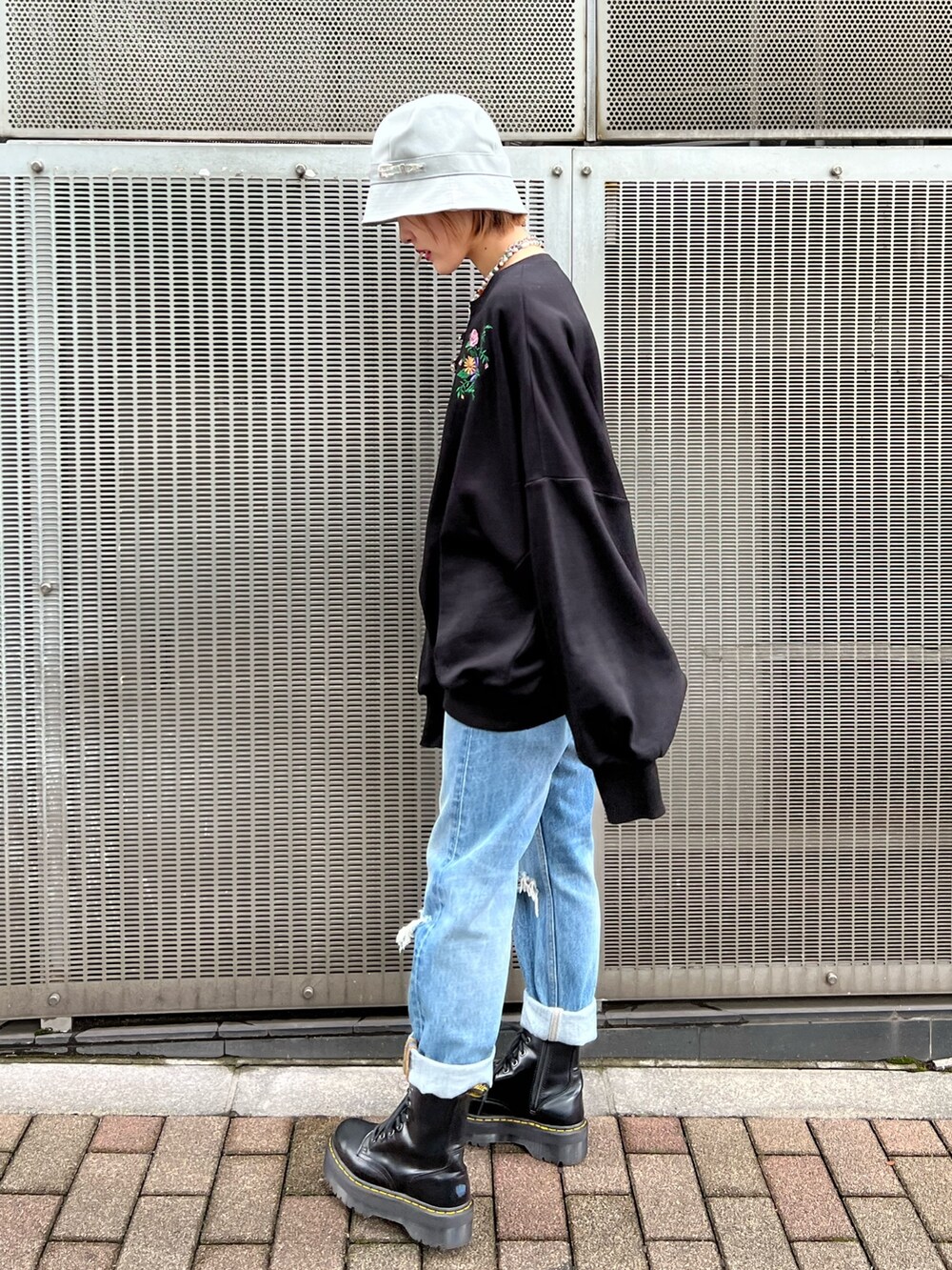 ブラック系のTシャツ/カットソー、ブルー系のデニムパンツ、ブラック系のブーツを着用したレディースの秋コーディネートの2枚目の写真