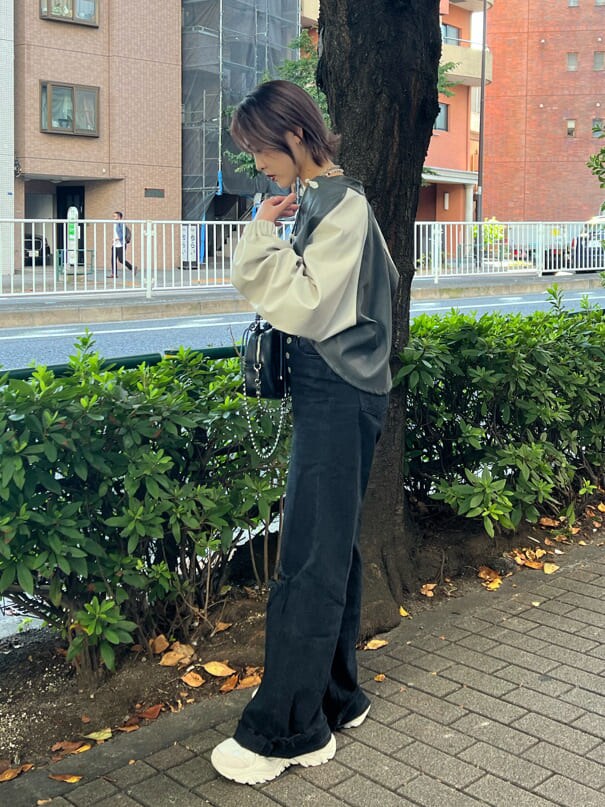 ブラック系のニット/セーター、ホワイト系のスニーカー、ブラック系のデニムパンツを着用したレディースの秋コーディネートの2枚目の写真