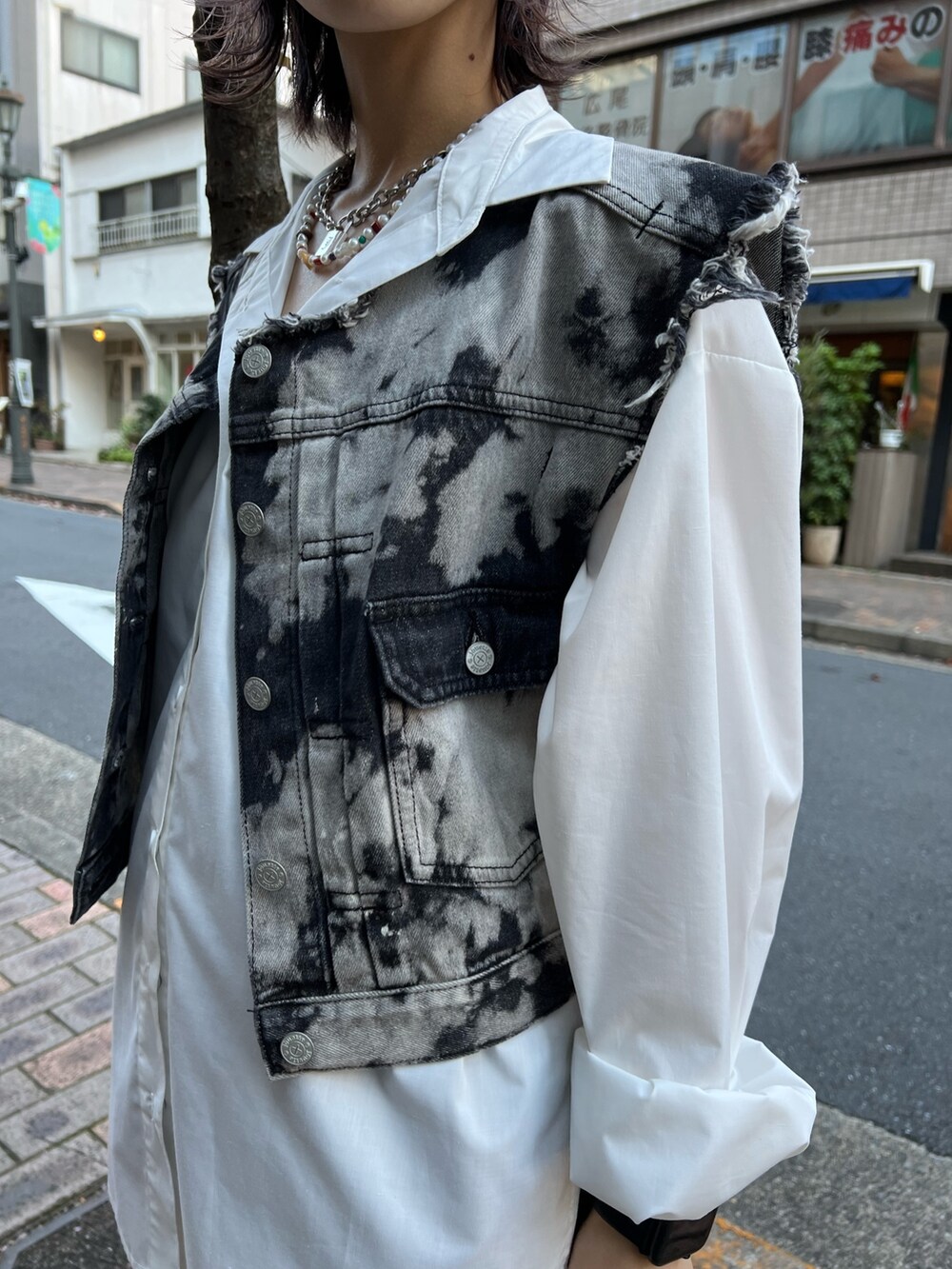 ブラック系のデニムジャケット、ホワイト系のシャツ/ブラウス、ブラック系のデニムパンツを着用したレディースの冬コーディネートの6枚目の写真