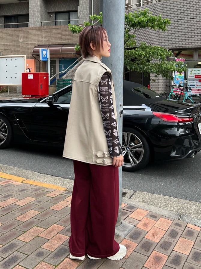 ブラック系のキャミソール、ホワイト系のスニーカー、ホワイト系のライダースジャケットを着用したレディースの秋コーディネートの4枚目の写真