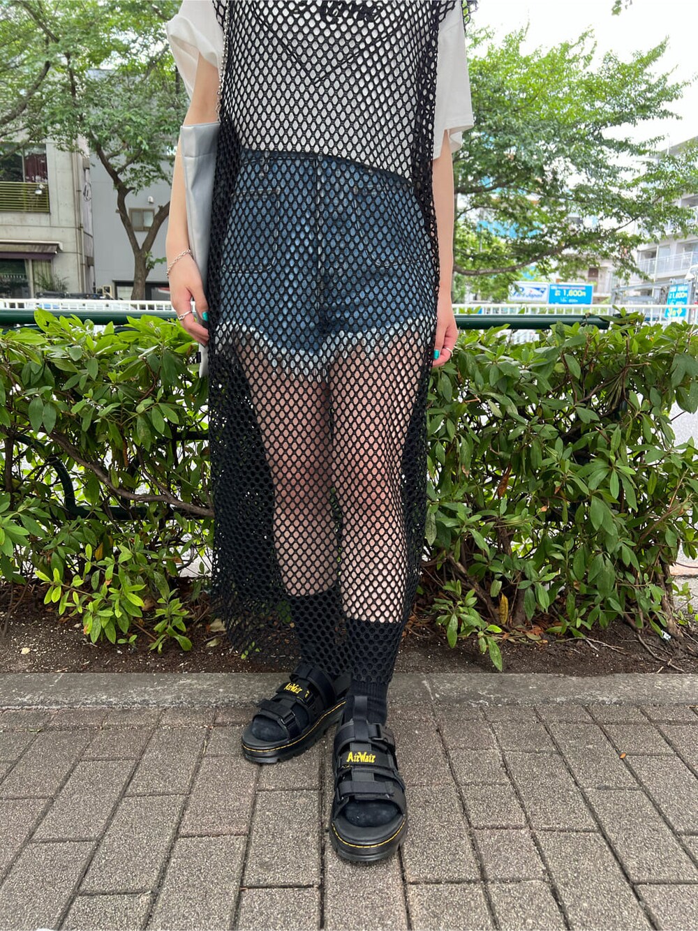 ブルー系のデニムパンツ、ブラック系のワンピース、ホワイト系のTシャツ/カットソーを着用したレディースの夏コーディネートの7枚目の写真