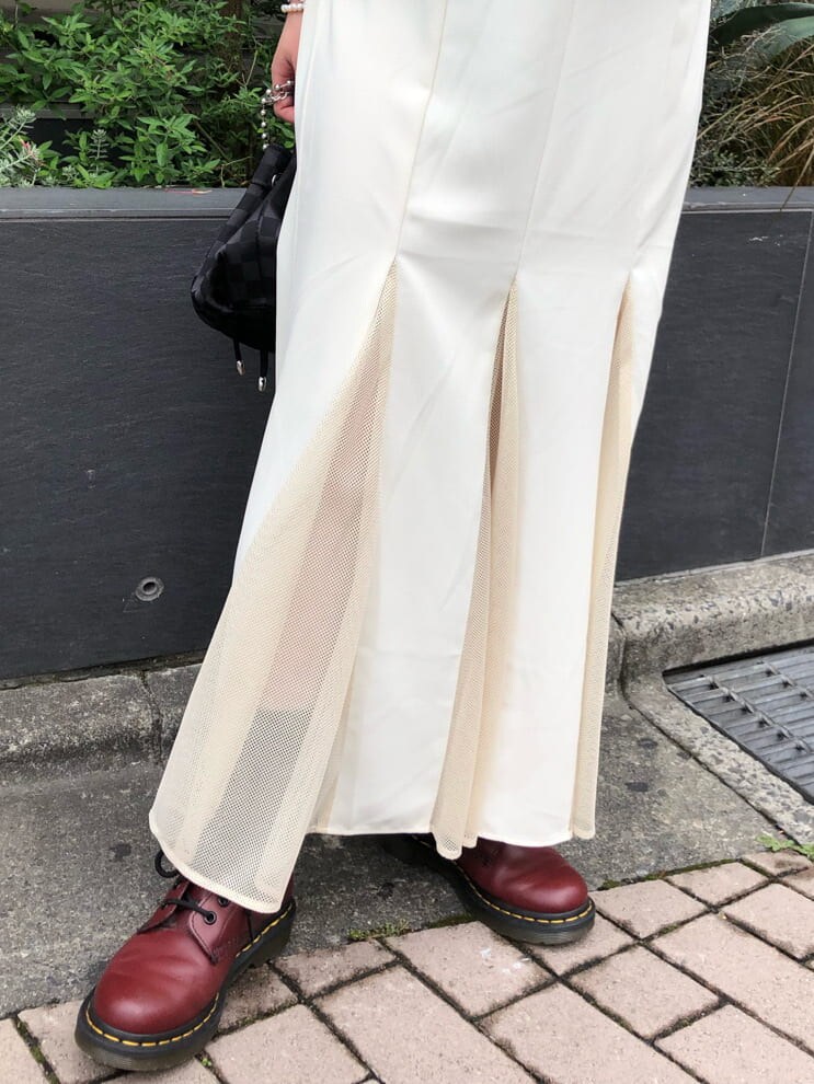 レッド系のニット/セーター、ホワイト系のスカート、ブラック系のショルダーバッグを着用したレディースの夏コーディネートの6枚目の写真