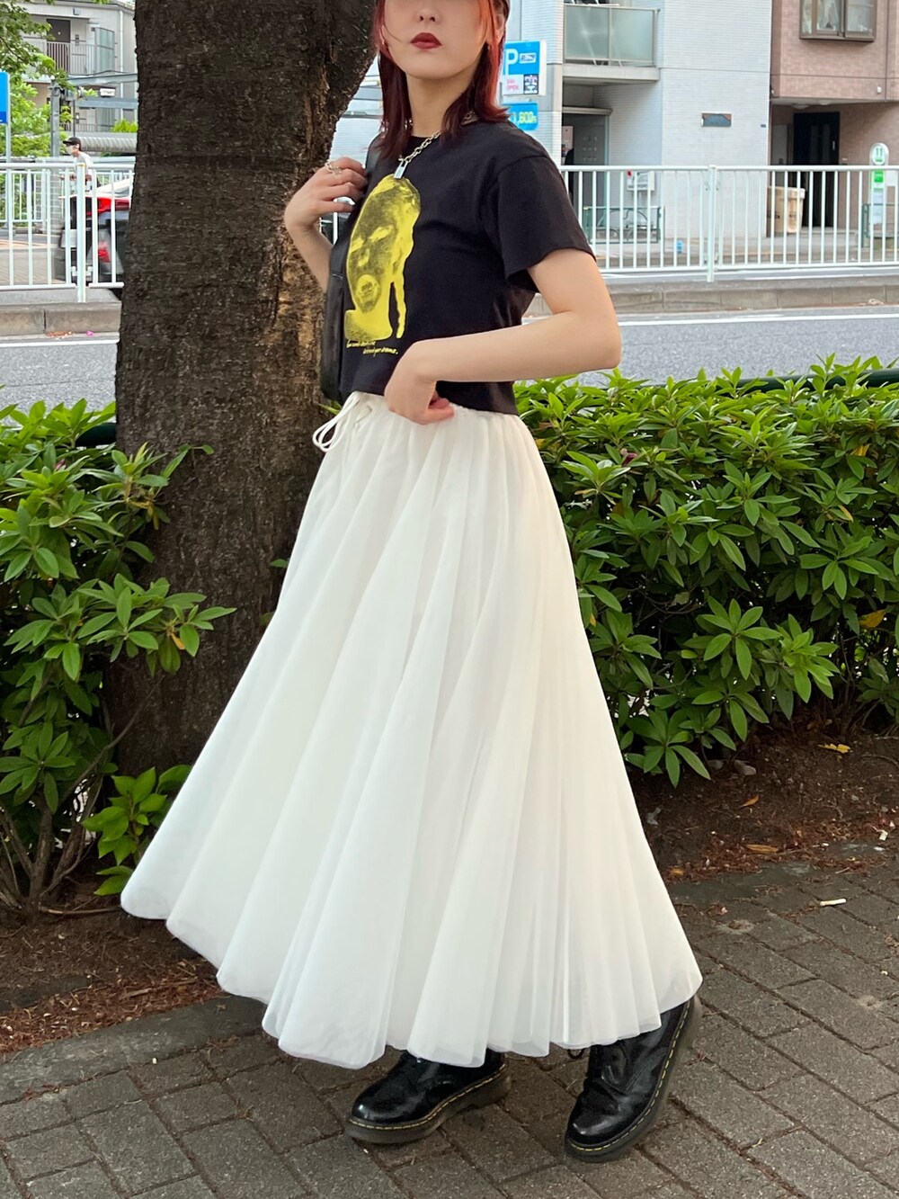 ブラック系のTシャツ/カットソー、ホワイト系のスカート、ブラック系のハンドバッグを着用したレディースの夏コーディネートの2枚目の写真