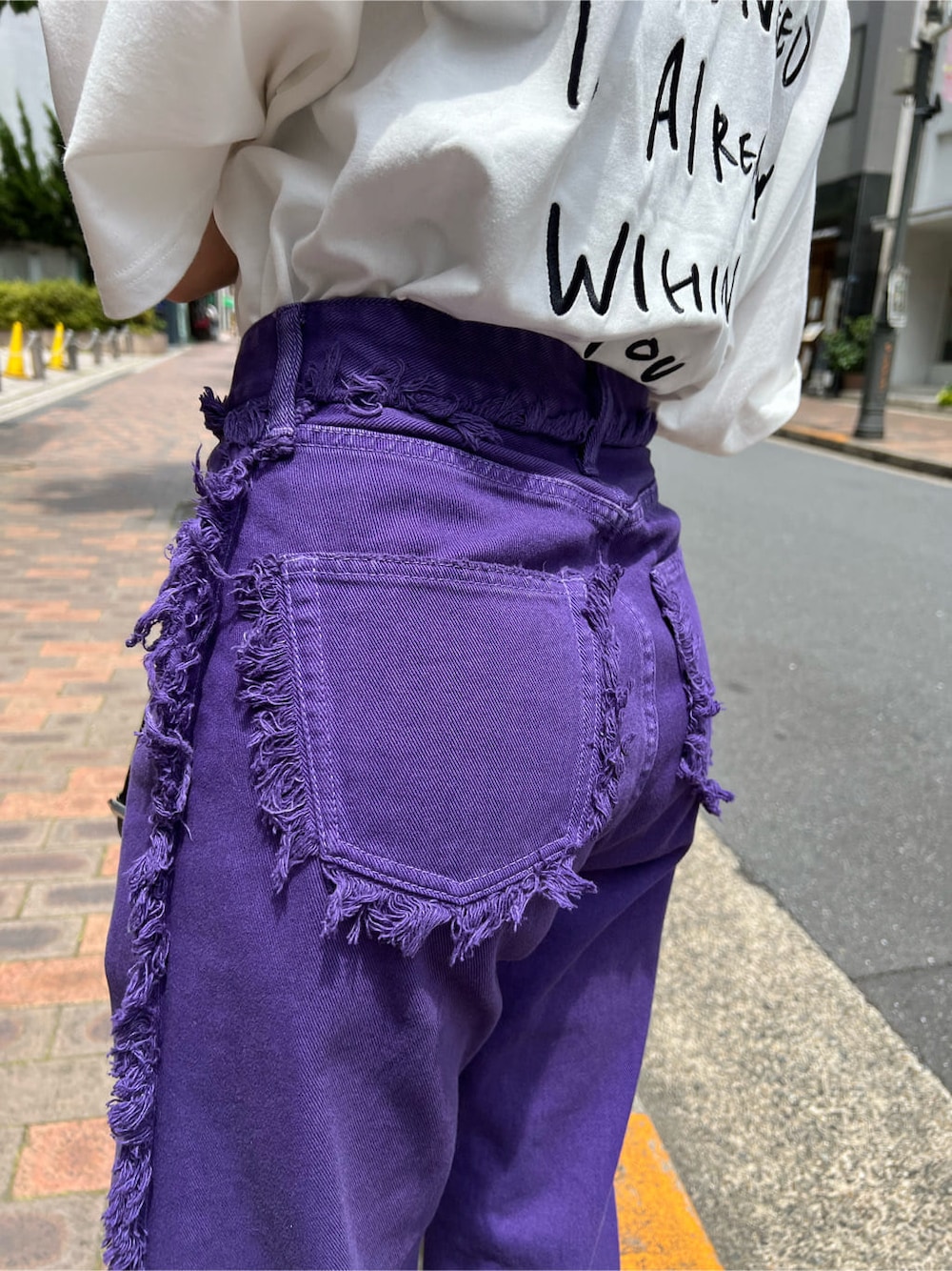 ブラック系のハンドバッグ、ホワイト系のTシャツ/カットソー、パープル系のデニムパンツを着用したレディースの夏コーディネートの9枚目の写真