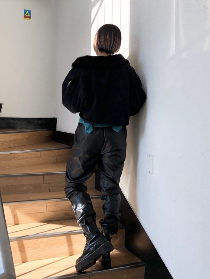 ブラック系のその他パンツ、ブラック系のミリタリージャケット、ブルー系のニット/セーターを着用したレディースの冬コーディネートの3枚目の写真