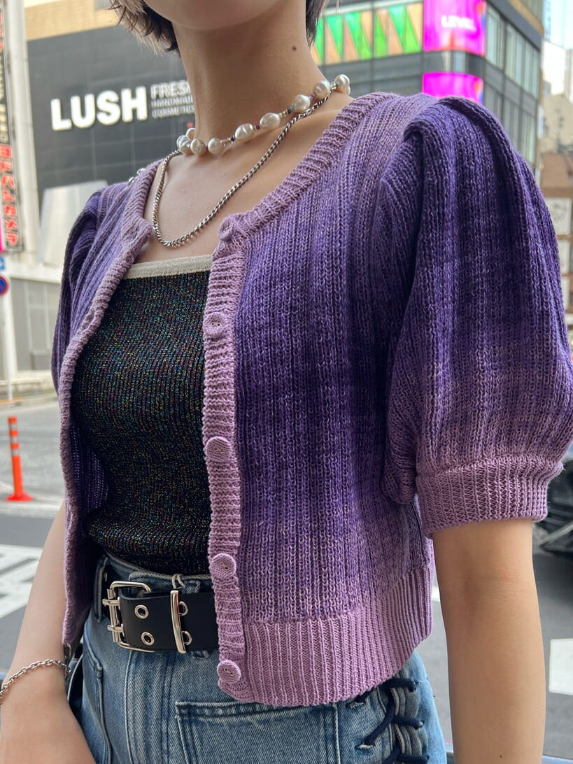 ブラック系のハンドバッグ、ブラック系のニット/セーター、ブルー系のデニムパンツを着用したレディースの夏コーディネートの6枚目の写真