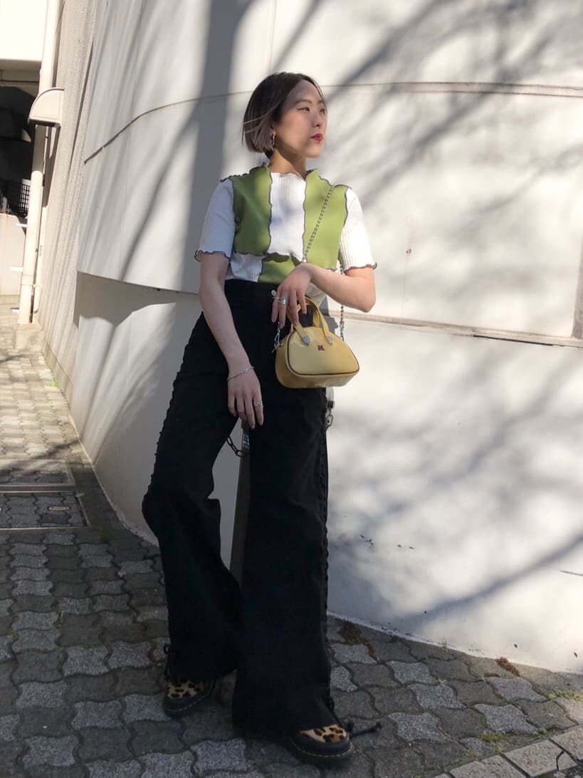 イエロー系のボストンバッグ、ブラック系のデニムパンツ、グリーン系のTシャツ/カットソーを着用したレディースの夏コーディネートの6枚目の写真