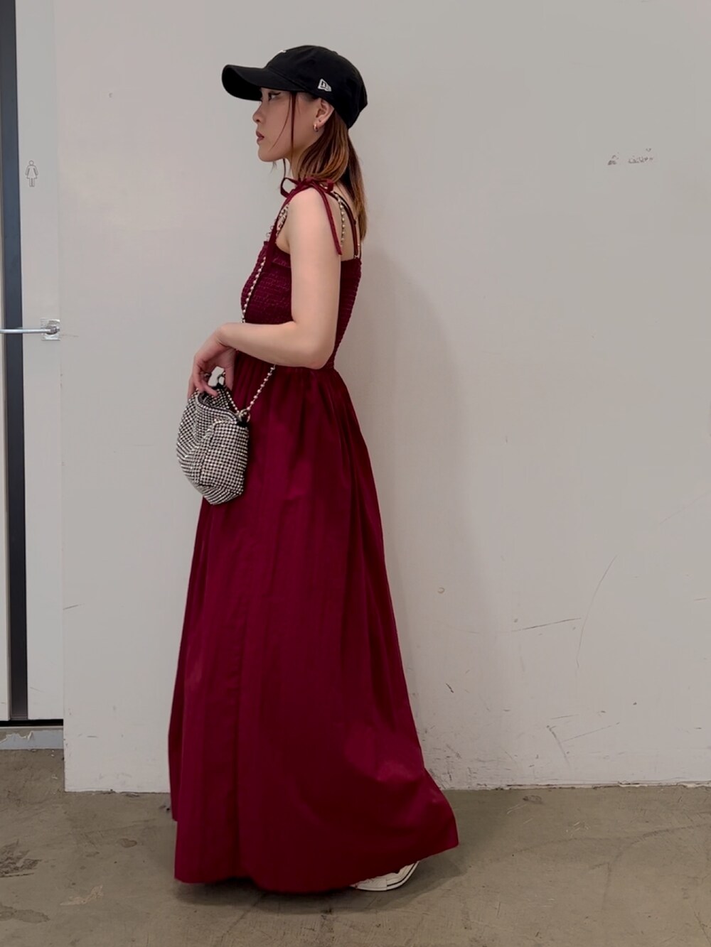 レッド系のワンピース、ホワイト系のショルダーバッグ、パープル系のスニーカーを着用したレディースの夏コーディネートの3枚目の写真