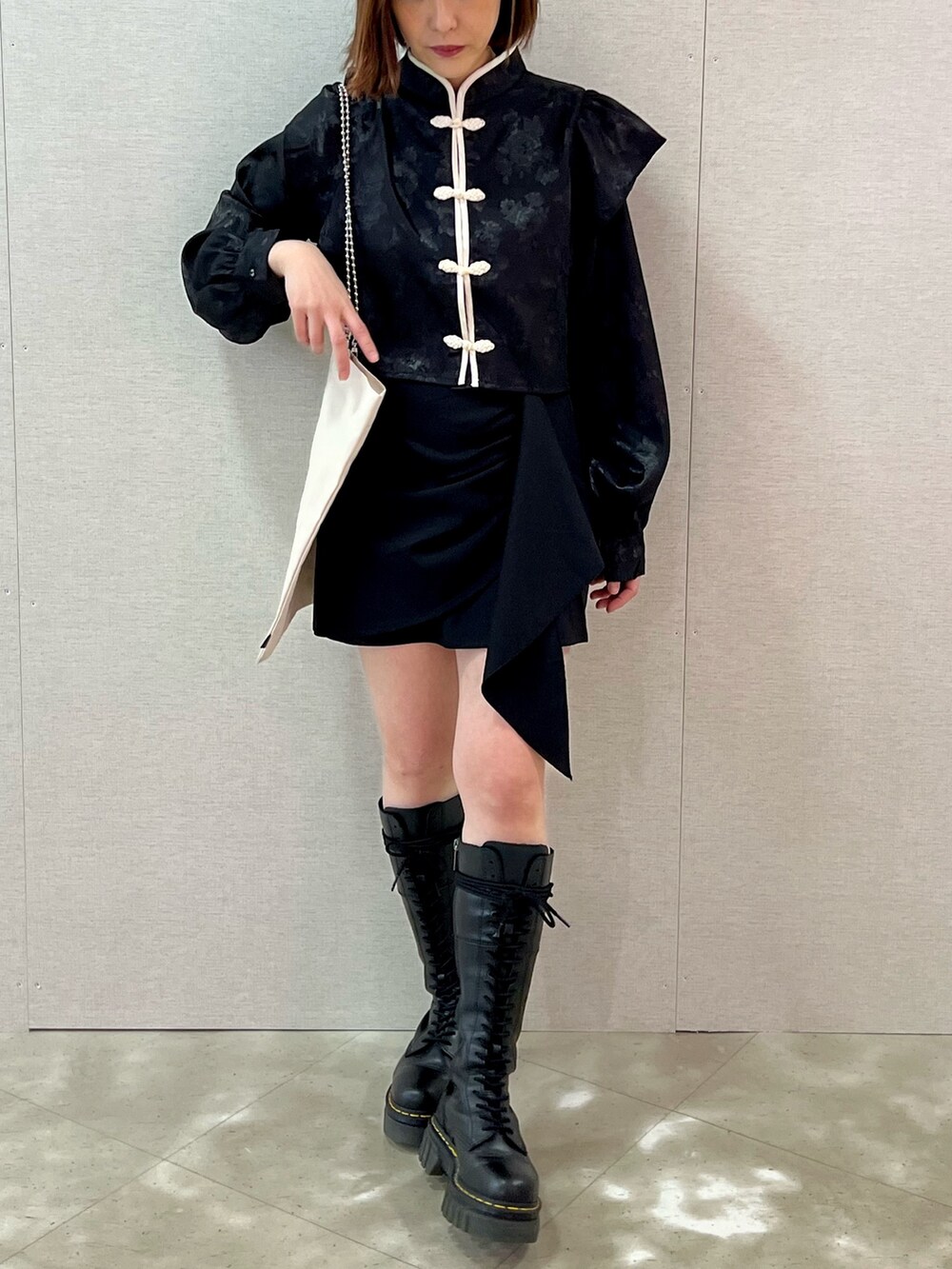 ピンク系のシャツ/ブラウス、ブラック系のスカート、ホワイト系のトートバッグを着用したレディースの春コーディネートの4枚目の写真