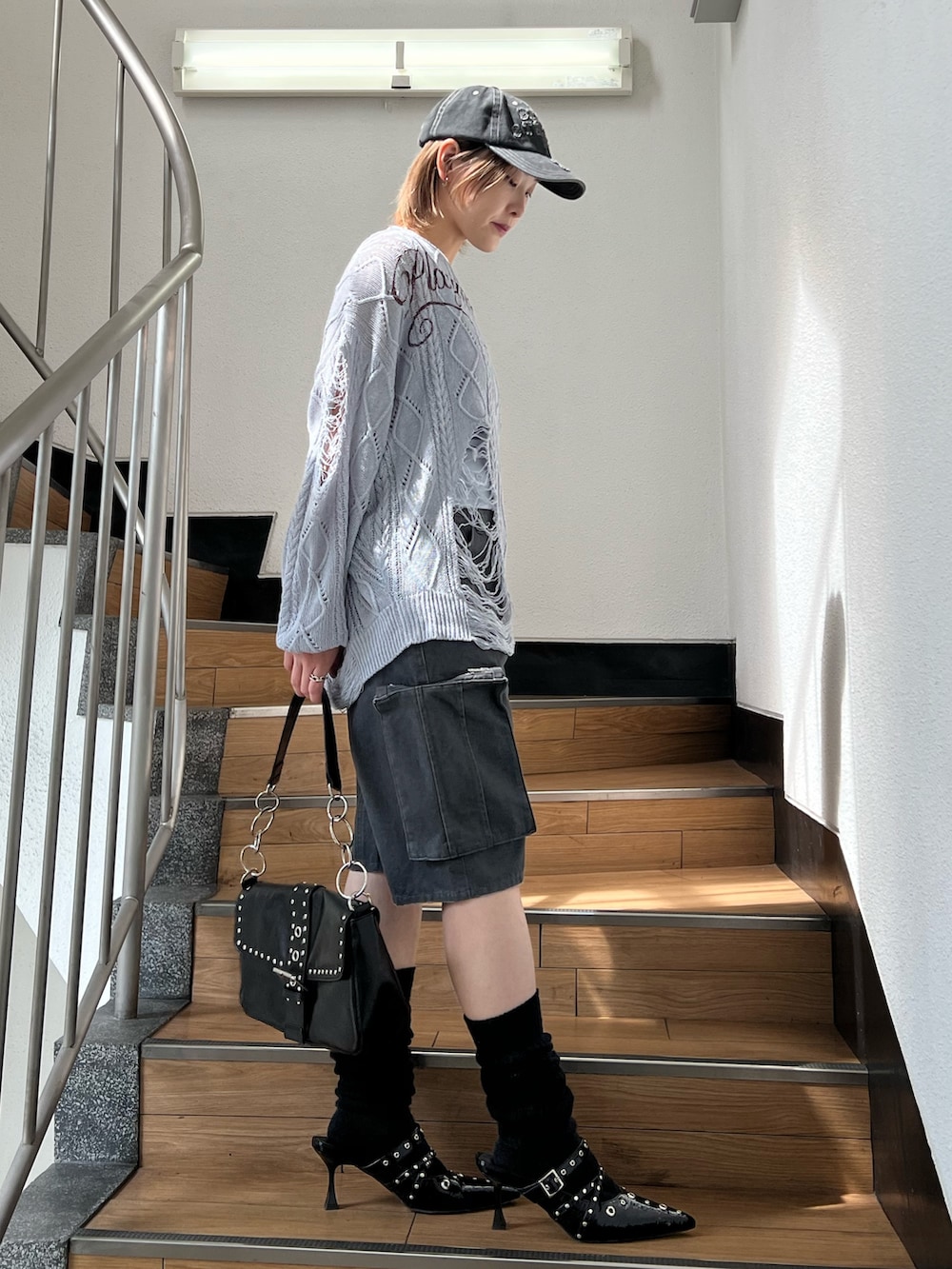 ブラック系のパンプス、ブラック系のカーゴパンツ、ブルー系のキャミソールを着用したレディースの春コーディネートの5枚目の写真