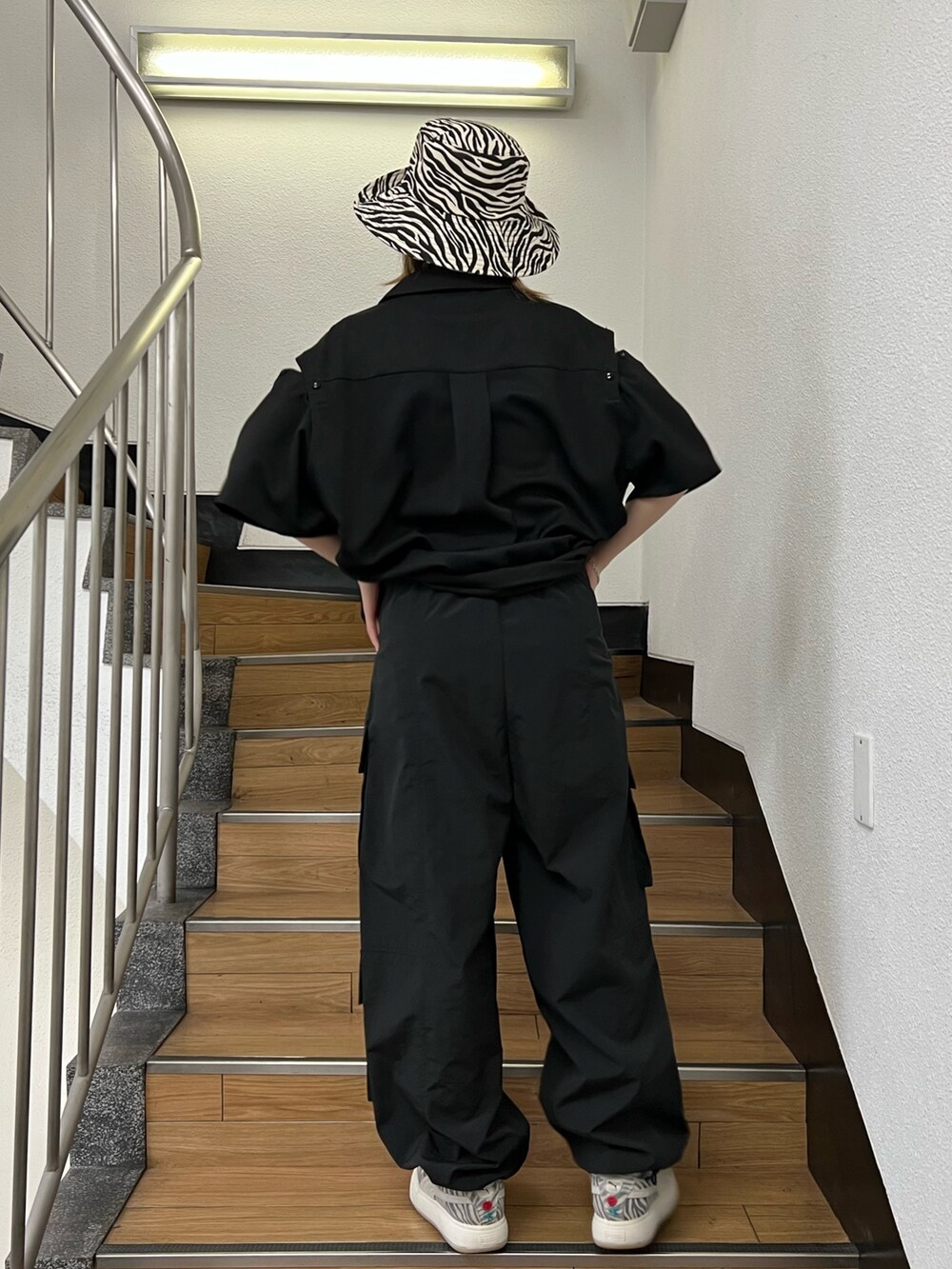 ブラック系のカーゴパンツ、ブラック系のシャツ/ブラウス、ホワイト系のハットを着用したレディースの春コーディネートの4枚目の写真