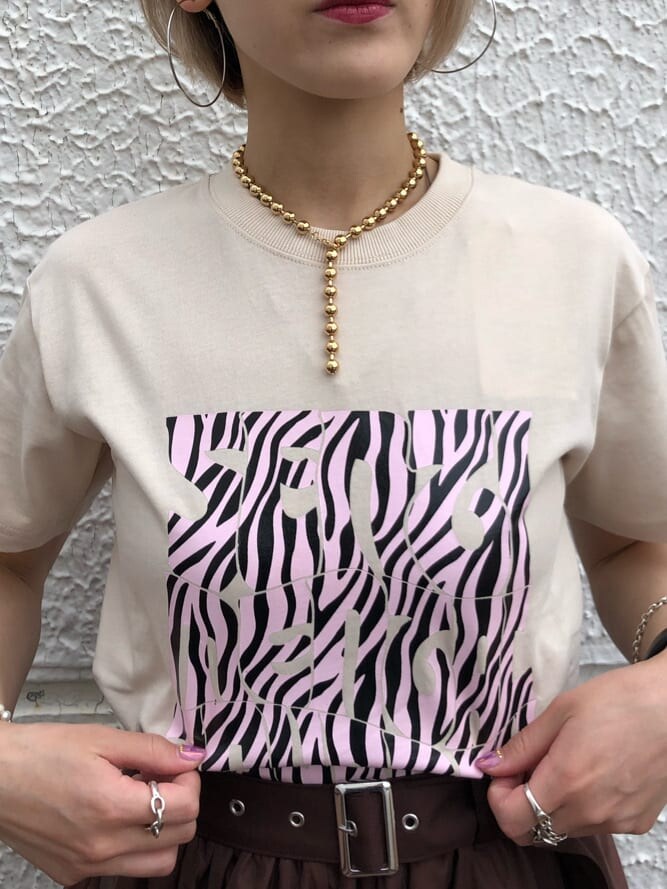 ブラウン系のスカート、ホワイト系のTシャツ/カットソー、ゴールド系のチョーカーを着用したレディースの夏コーディネートの6枚目の写真