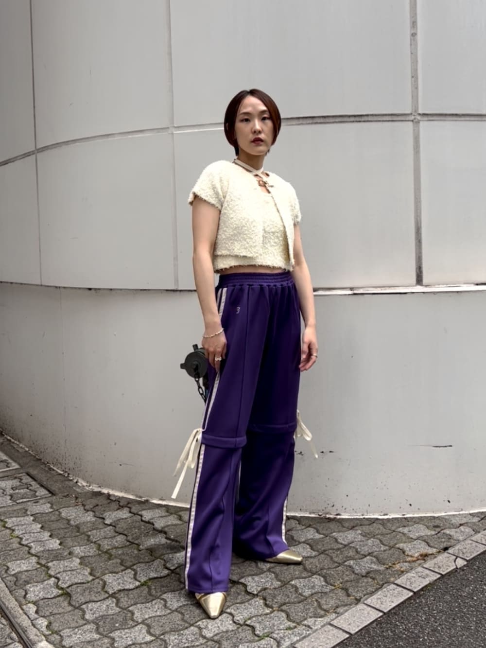 ホワイト系のアンサンブル、パープル系のその他パンツ、ゴールド系のパンプスを着用したレディースの夏コーディネートの6枚目の写真