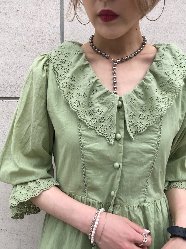 ブラック系のハンドバッグ、グリーン系のワンピース、シルバー系のチョーカーを着用したレディースの夏コーディネートの4枚目の写真