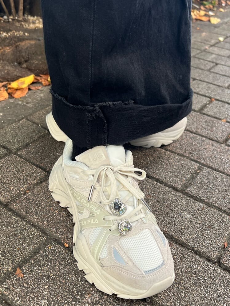 ブラック系のニット/セーター、ホワイト系のスニーカー、ブラック系のデニムパンツを着用したレディースの秋コーディネートの10枚目の写真