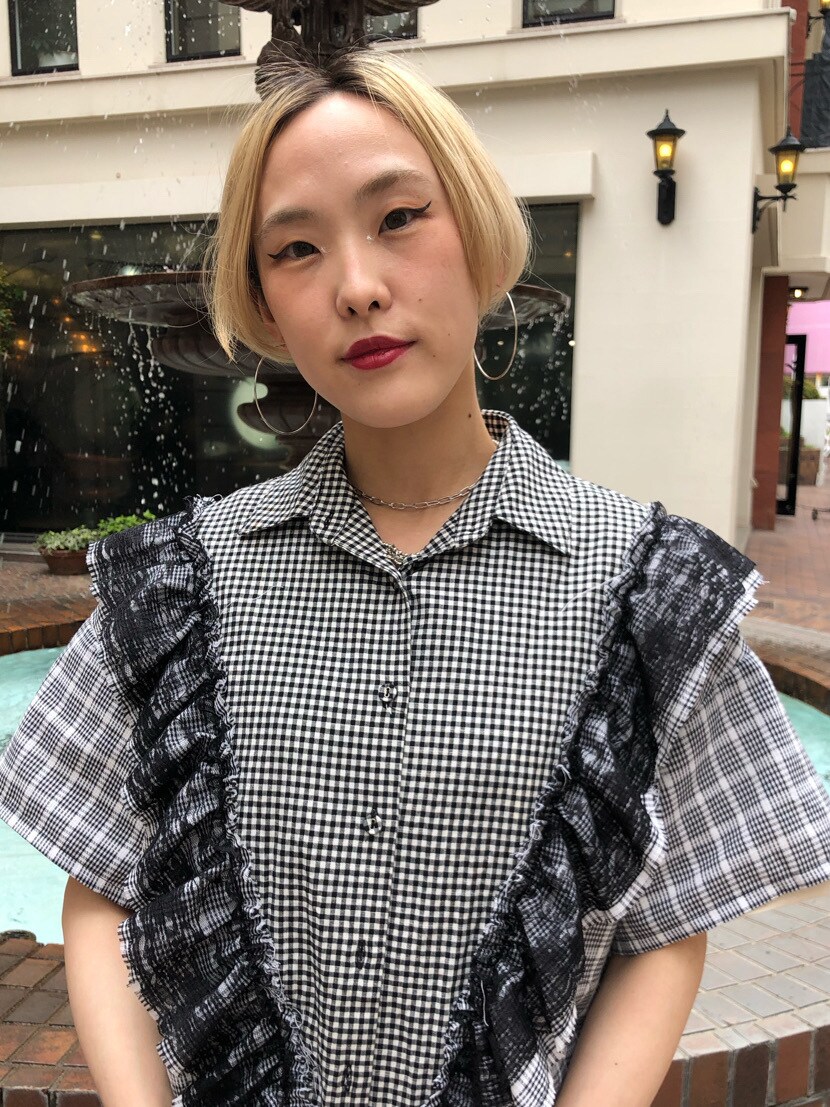 ブラック系のスカート、ブラック系のブーツ、ホワイト系のTシャツ/カットソーを着用したレディースの春コーディネートの5枚目の写真