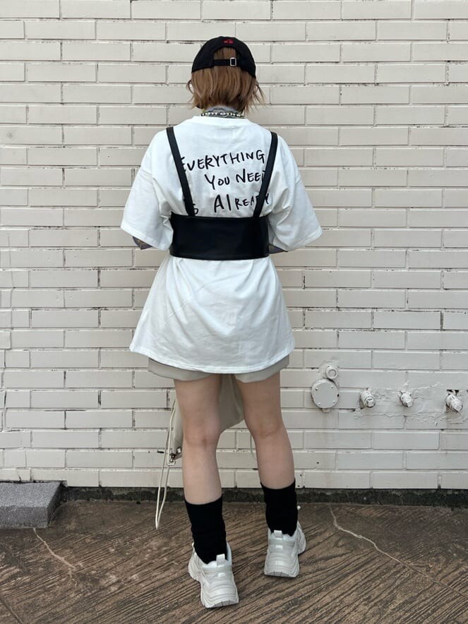 ホワイト系のスニーカー、ホワイト系のバックパック/リュック、ホワイト系のTシャツ/カットソーを着用したレディースの秋コーディネートの4枚目の写真