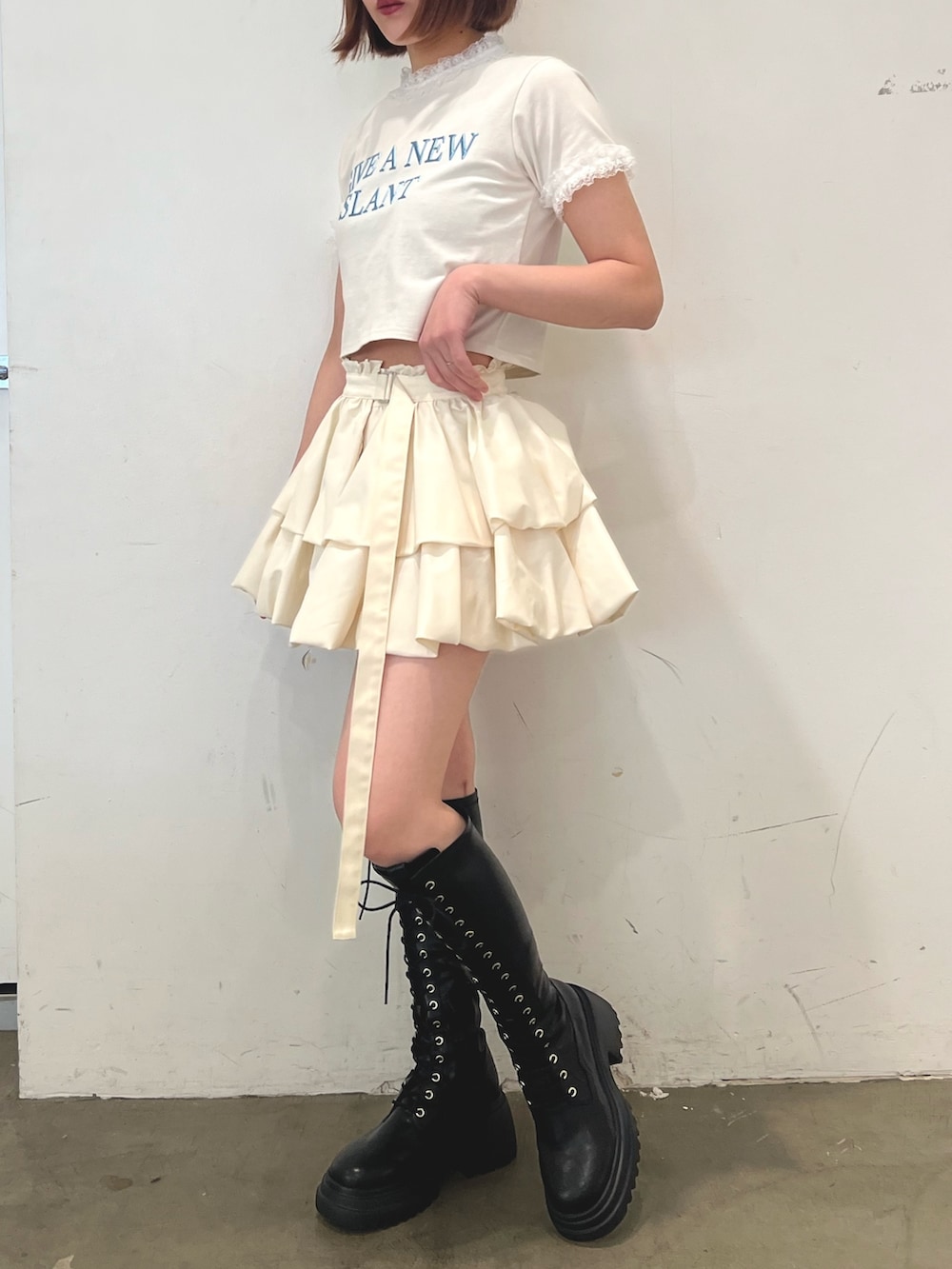 ホワイト系のTシャツ/カットソー、ホワイト系のスカート、ブラック系のブーツを着用したレディースの春コーディネートの3枚目の写真