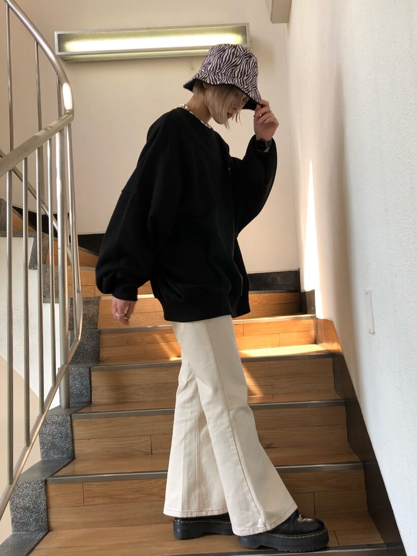 ホワイト系のデニムパンツ、ブラック系のスウェット、ブラック系のハットを着用したレディースの秋コーディネートの3枚目の写真