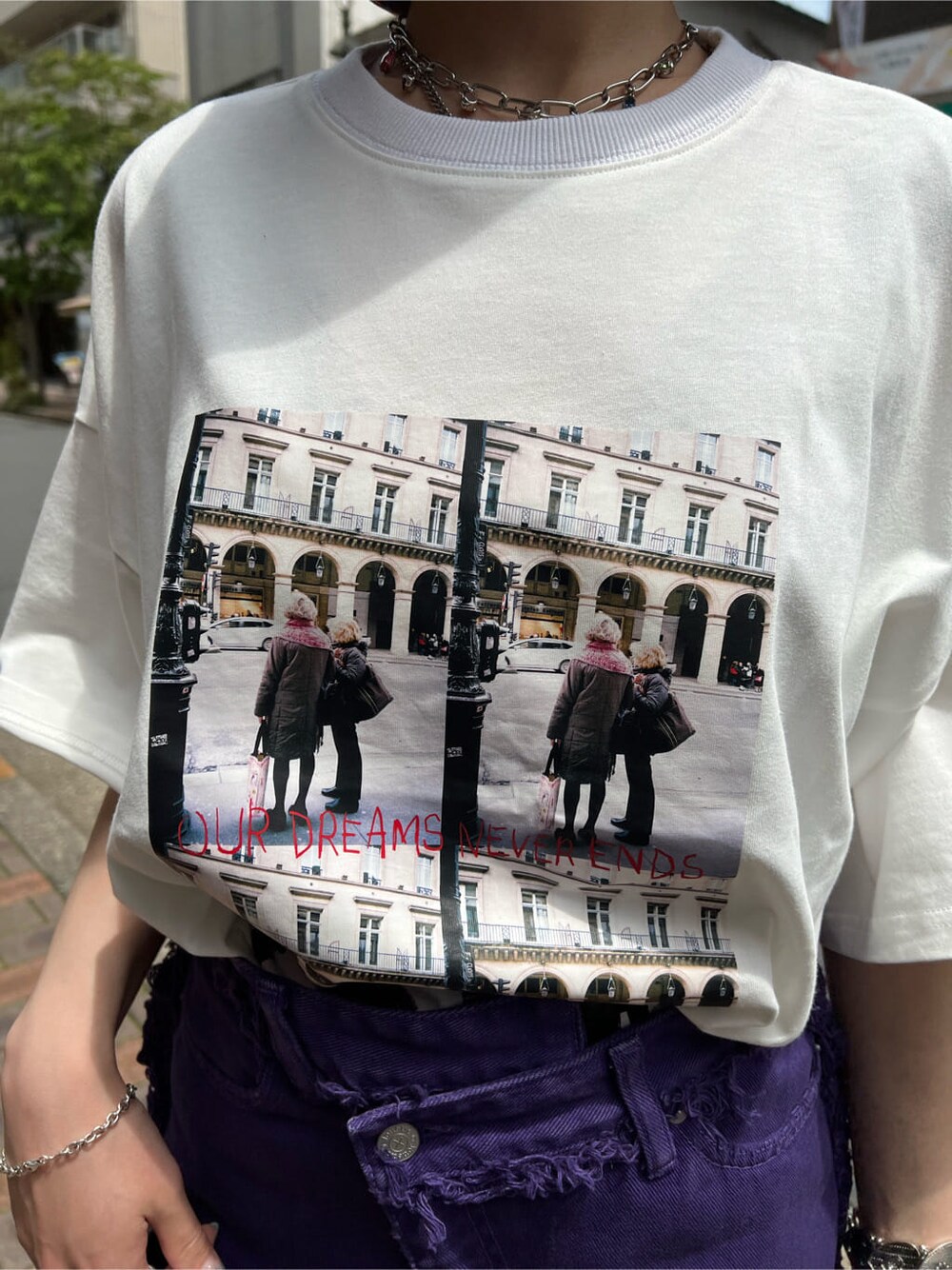 ブラック系のハンドバッグ、ホワイト系のTシャツ/カットソー、パープル系のデニムパンツを着用したレディースの夏コーディネートの5枚目の写真