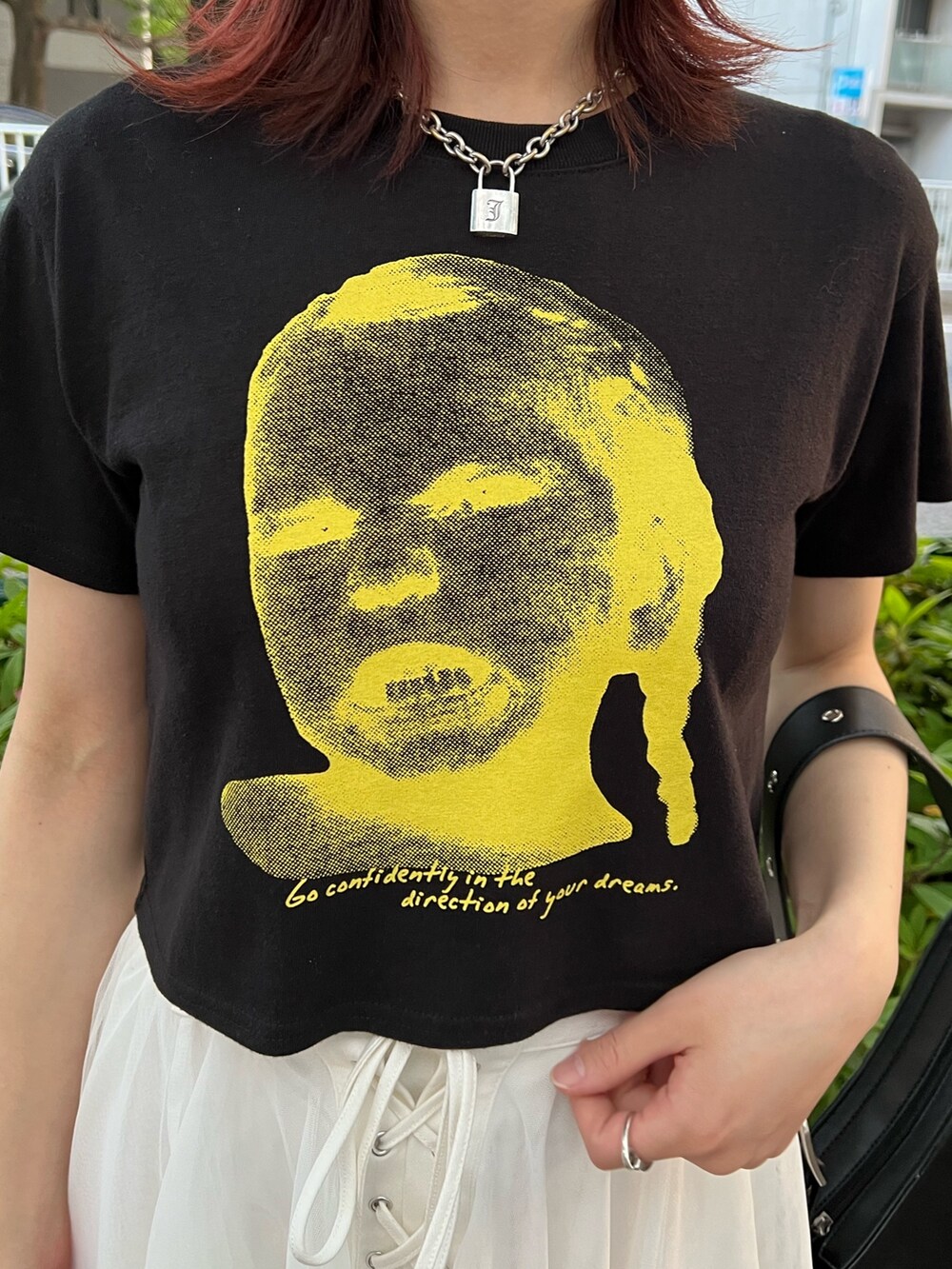 ブラック系のTシャツ/カットソー、ホワイト系のスカート、ブラック系のハンドバッグを着用したレディースの夏コーディネートの6枚目の写真