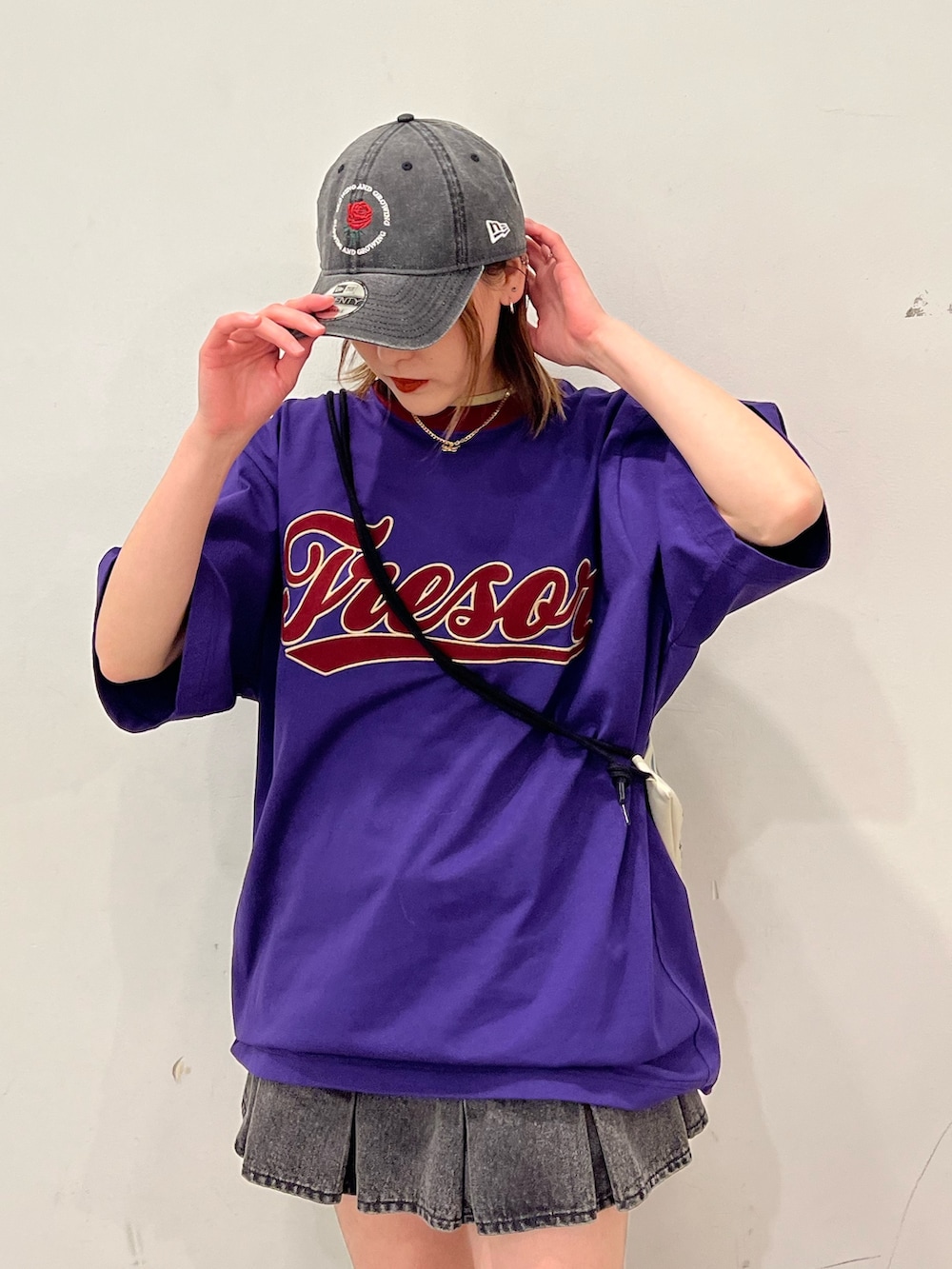 ブラック系のデニムパンツ、パープル系のTシャツ/カットソー、ホワイト系のショルダーバッグを着用したレディースの春コーディネートの5枚目の写真