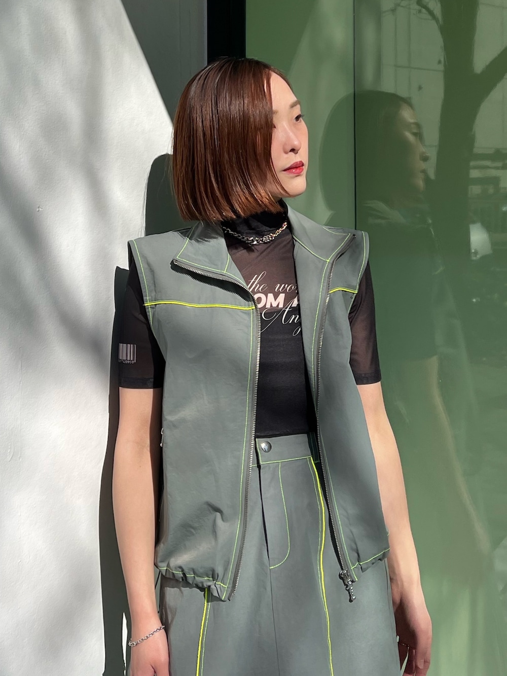 ブラック系のTシャツ/カットソー、グレー系のベスト、グレー系のスカートを着用したレディースの冬コーディネートの5枚目の写真