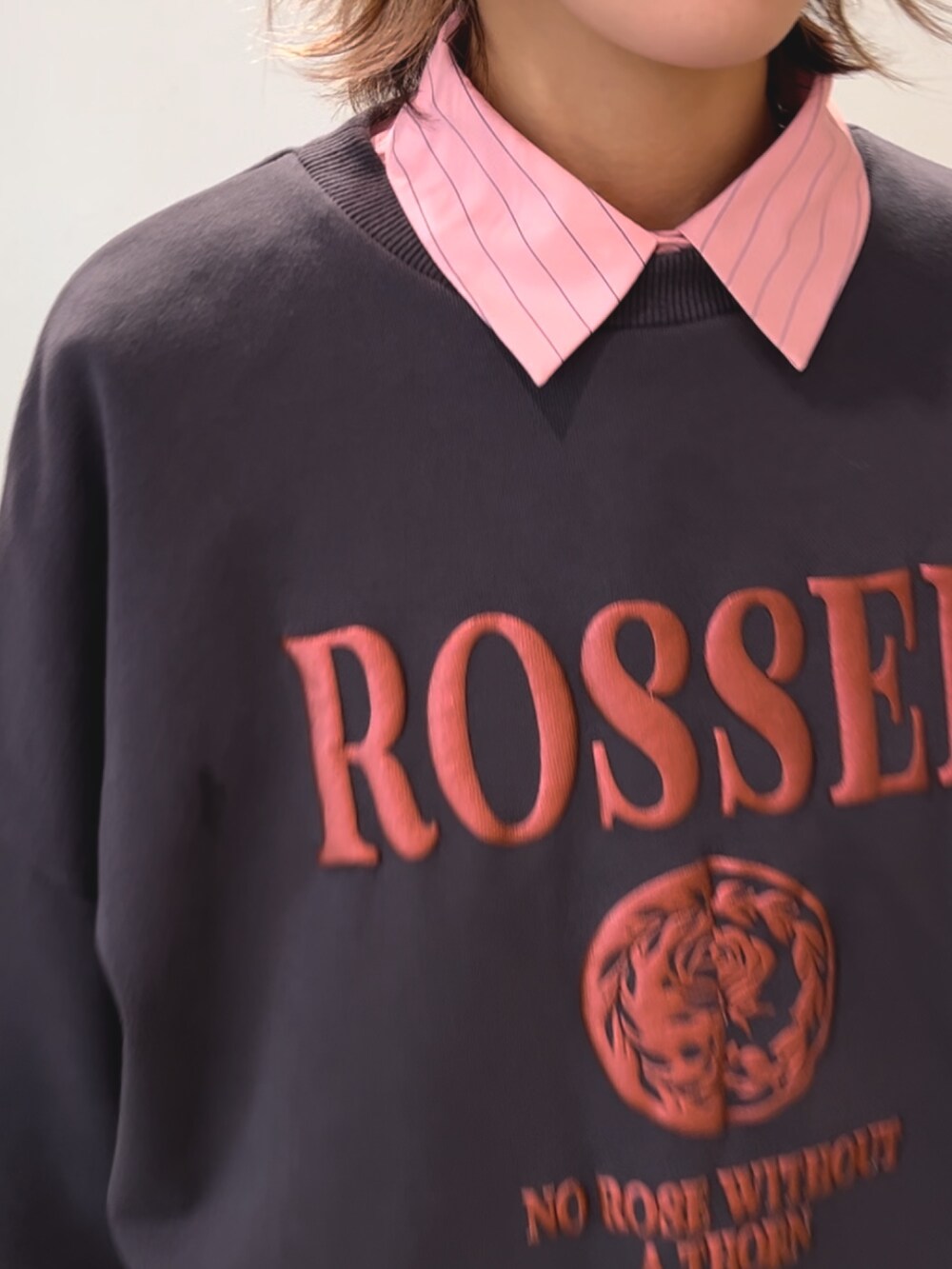 ブラック系のスウェット、ブラック系のデニムパンツ、ピンク系のシャツ/ブラウスを着用したレディースの秋コーディネートの4枚目の写真