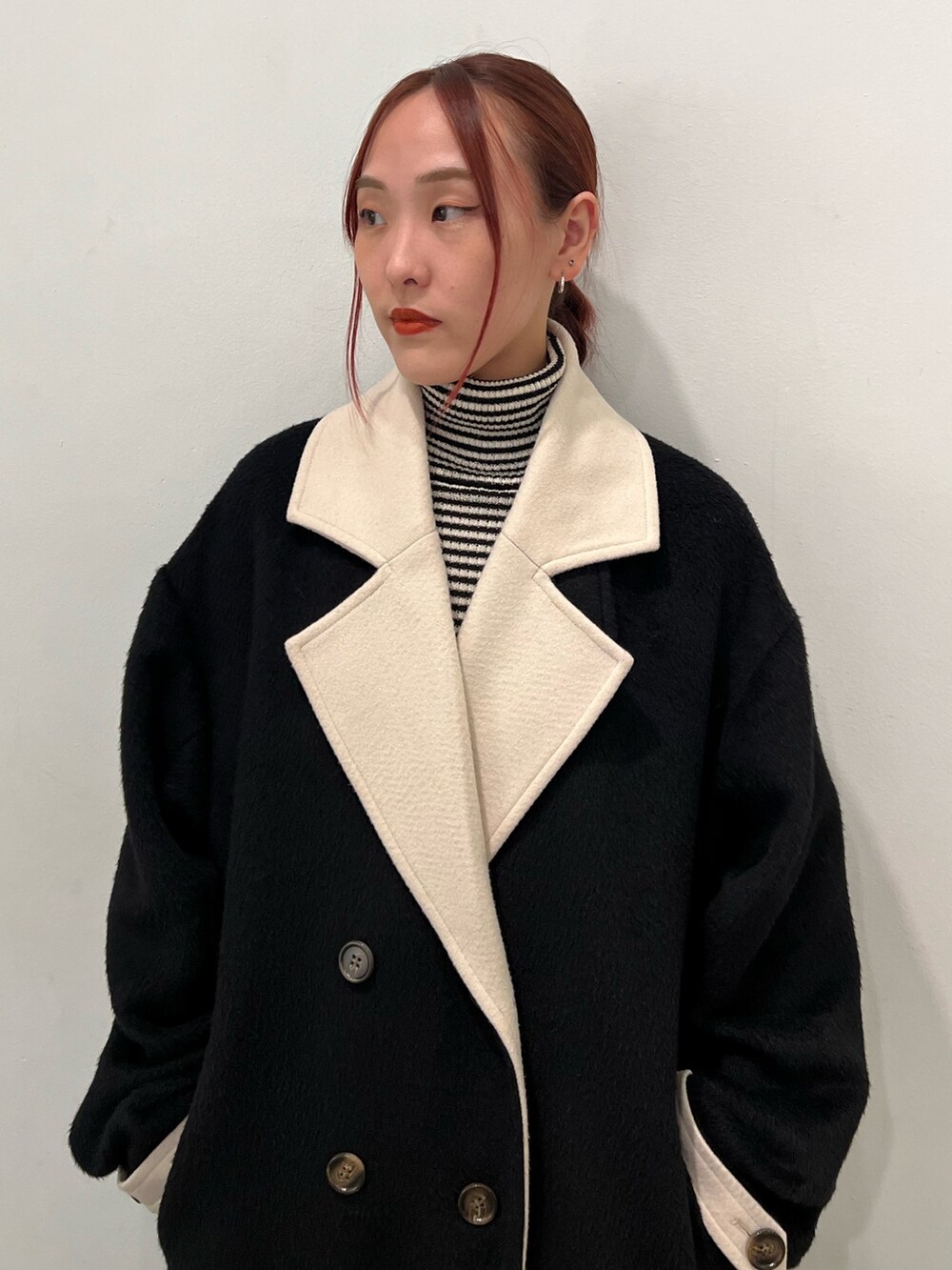 その他のニット/セーター、ブルー系のスカート、ブラック系のチェスターコートを着用したレディースの秋コーディネートの7枚目の写真