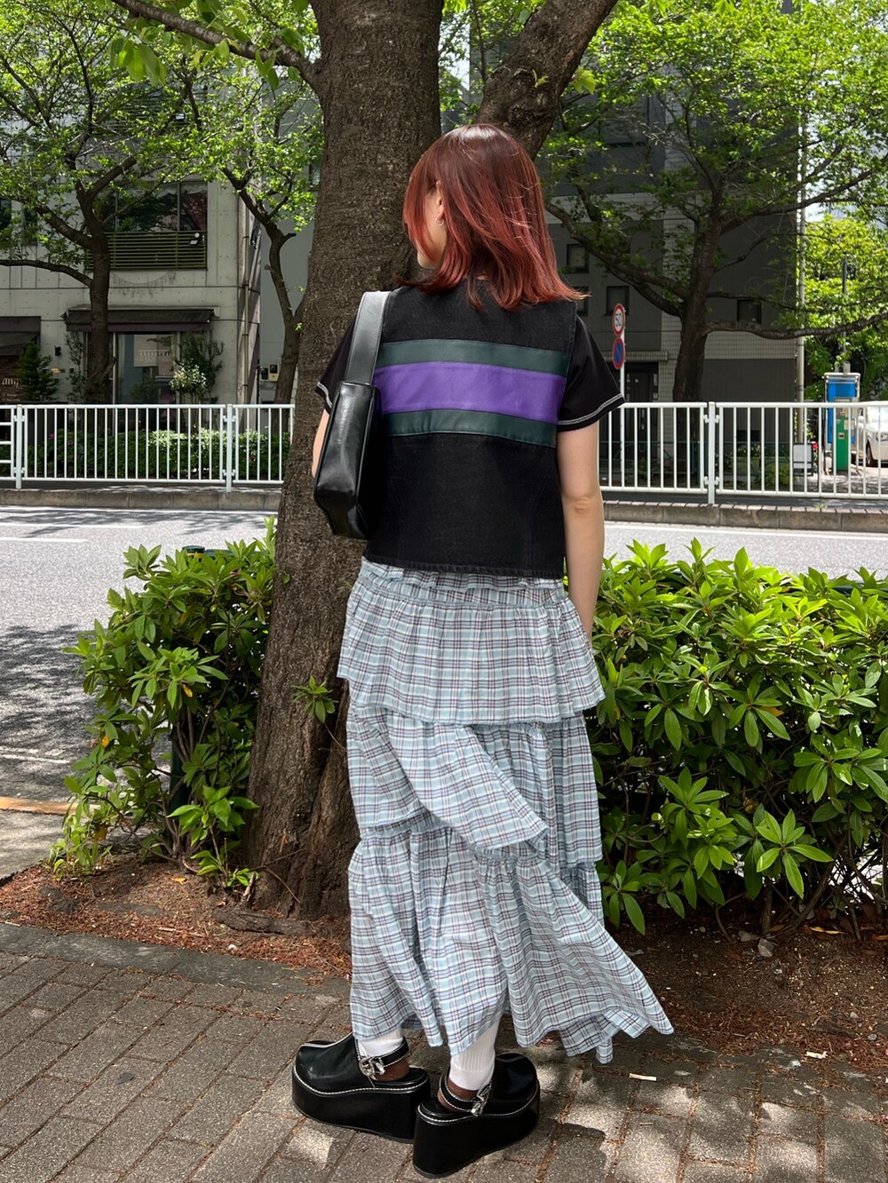 ブラック系のTシャツ/カットソー、ブラック系のベスト、ブラック系のハンドバッグを着用したレディースの夏コーディネートの4枚目の写真