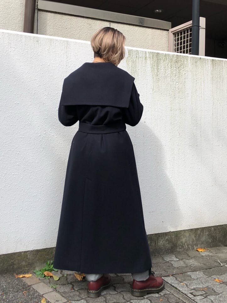 ブルー系のチェスターコート、ブラック系のデニムパンツ、ブラック系のニット/セーターを着用したレディースの秋コーディネートの6枚目の写真