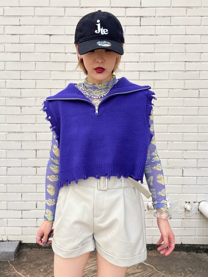 ホワイト系のスニーカー、パープル系のベスト、パープル系のその他トップスを着用したレディースの秋コーディネートの6枚目の写真