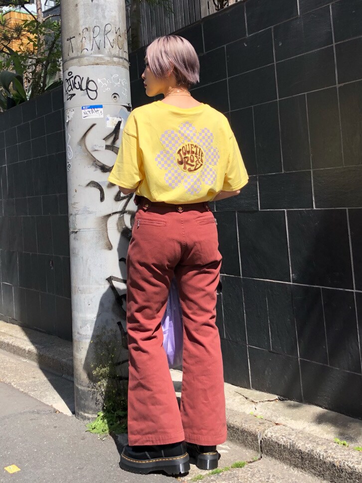 パープル系のトートバッグ、ブラウン系のデニムパンツ、イエロー系のTシャツ/カットソーを着用したレディースの春コーディネートの3枚目の写真