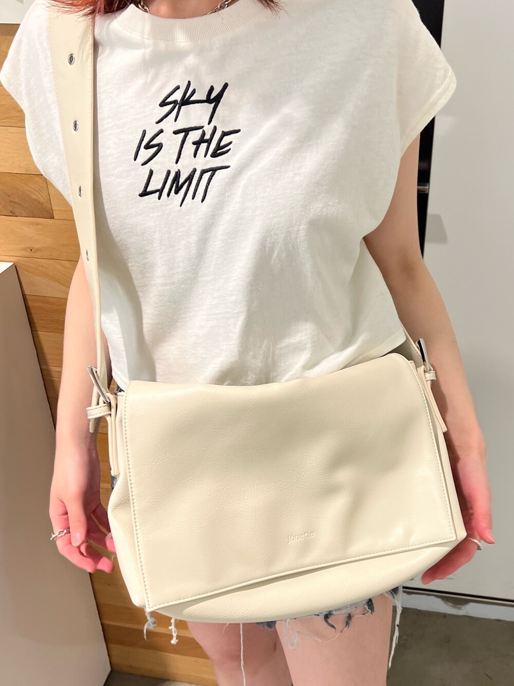 ホワイト系のタンクトップ、グリーン系のワンピース、ホワイト系のメッセンジャーバッグを着用したレディースの春コーディネートの9枚目の写真