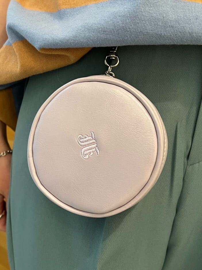 ブルー系のスラックス、グリーン系のハンドバッグ、ブルー系のTシャツ/カットソーを着用したレディースの夏コーディネートの8枚目の写真