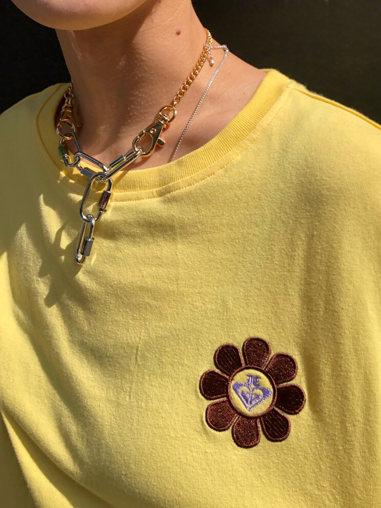 パープル系のトートバッグ、ブラウン系のデニムパンツ、イエロー系のTシャツ/カットソーを着用したレディースの春コーディネートの5枚目の写真