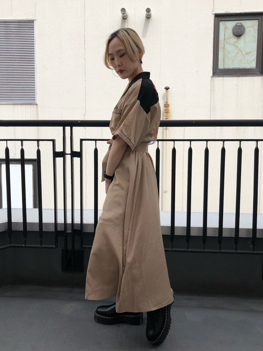 ブラック系のブーツ、パープル系のショルダーバッグ、ベージュ系のワンピースを着用したレディースの春コーディネートの2枚目の写真