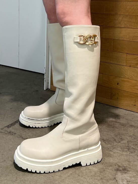 ホワイト系のブーツ、ホワイト系のベスト、ホワイト系のハンドバッグを着用したレディースの春コーディネートの10枚目の写真