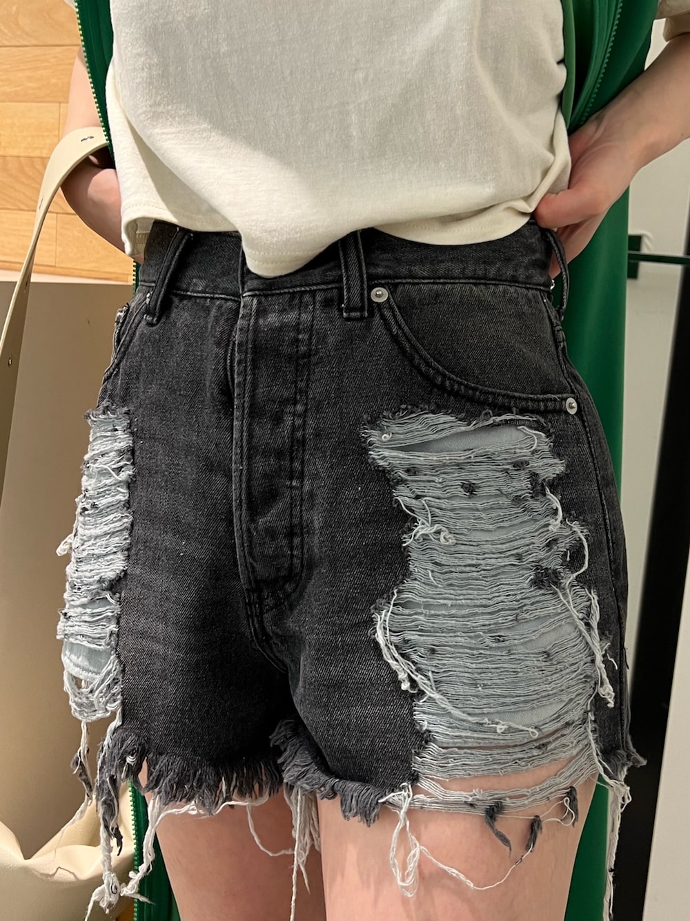 ホワイト系のタンクトップ、グリーン系のワンピース、ホワイト系のメッセンジャーバッグを着用したレディースの春コーディネートの8枚目の写真