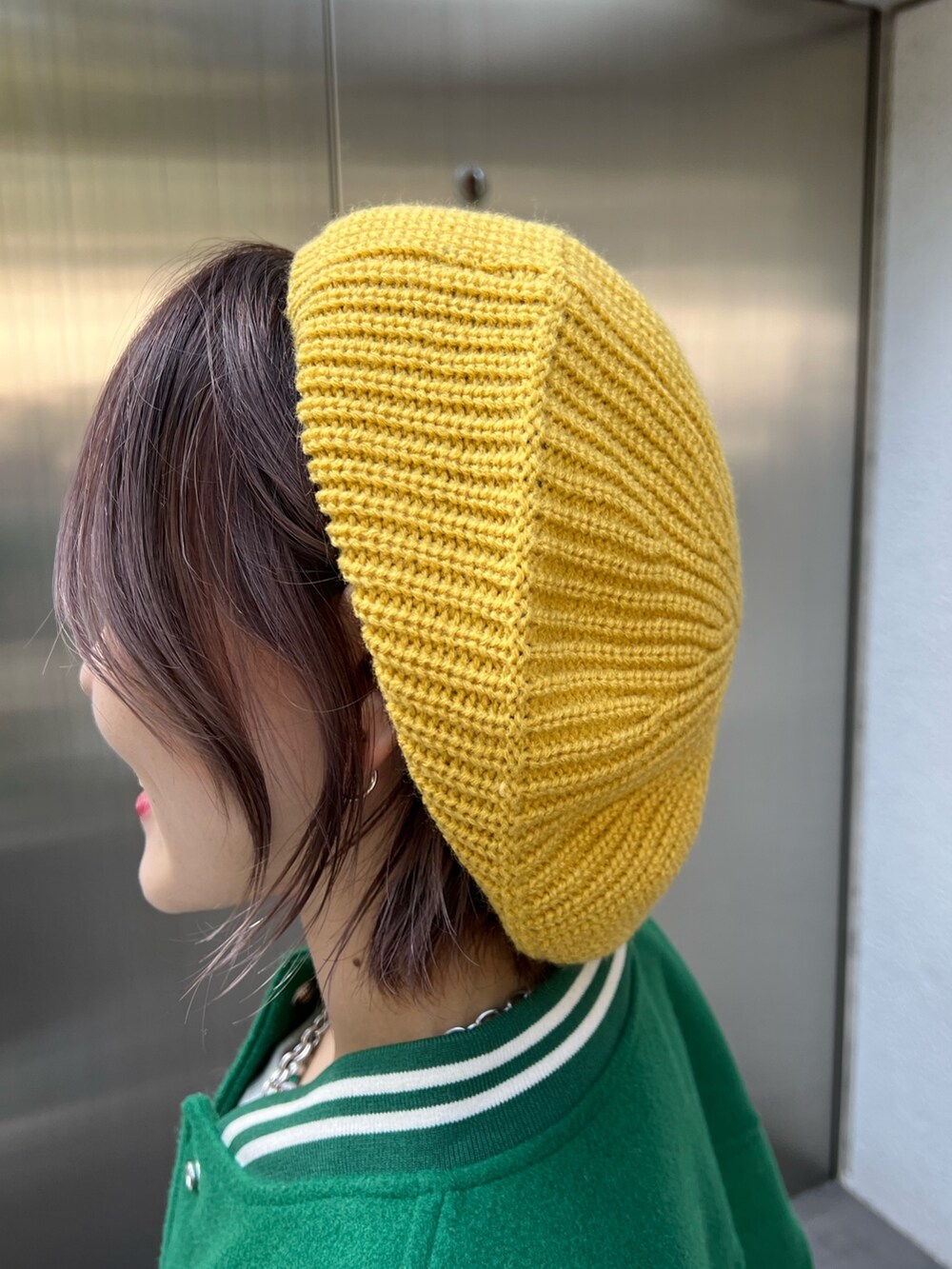 グレー系のスウェット、グリーン系のスタジャン、ホワイト系のスニーカーを着用したレディースの秋コーディネートの9枚目の写真