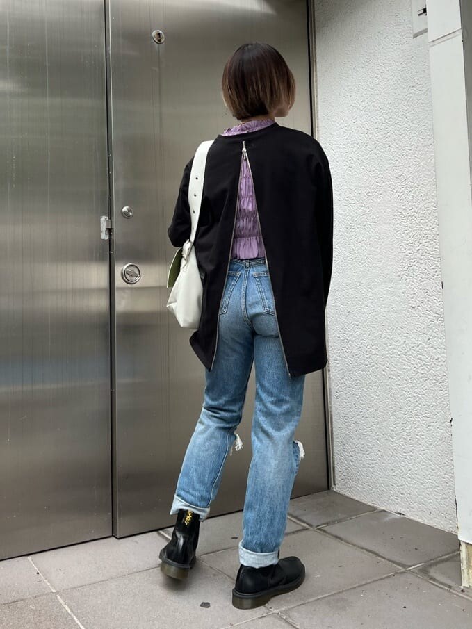 ブルー系のデニムパンツ、ホワイト系のハンドバッグ、パープル系のTシャツ/カットソーを着用したレディースの夏コーディネートの4枚目の写真