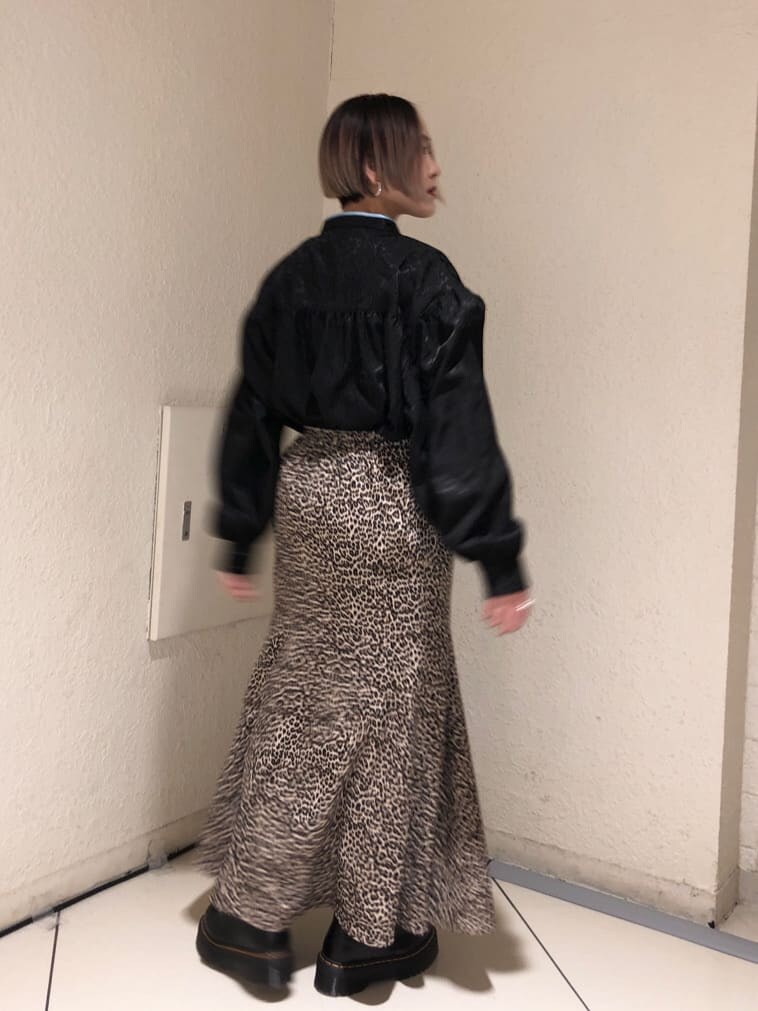 ブラック系のシャツ/ブラウス、ブラウン系のスカート、ブラック系のブーツを着用したレディースの春コーディネートの3枚目の写真