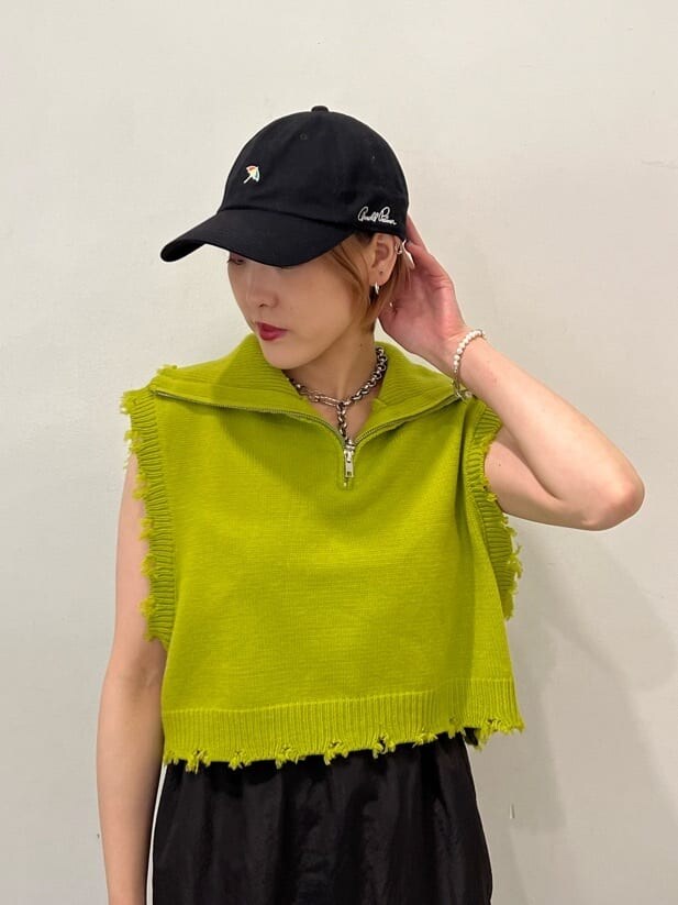 ホワイト系のローファー、グリーン系のベスト、ブラック系のジャンパースカートを着用したレディースの秋コーディネートの8枚目の写真