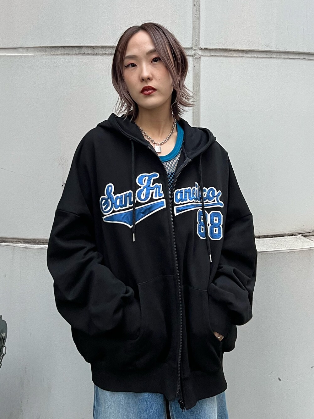 ブルー系のスカート、ブラック系のパーカー、ブルー系のタンクトップを着用したレディースの春コーディネートの6枚目の写真