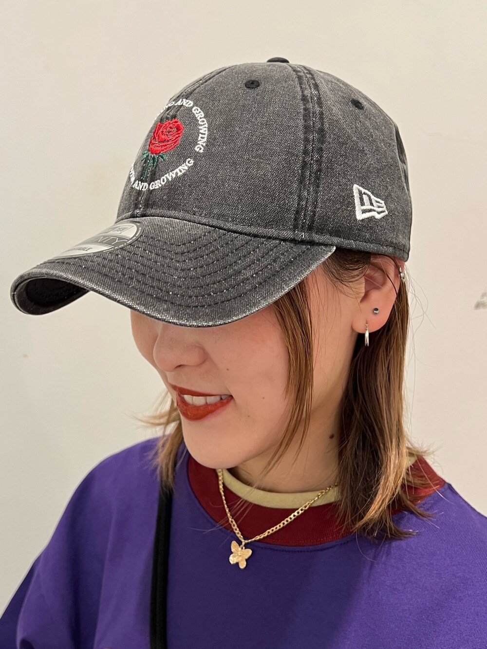 ブラック系のデニムパンツ、パープル系のTシャツ/カットソー、ホワイト系のショルダーバッグを着用したレディースの春コーディネートの9枚目の写真