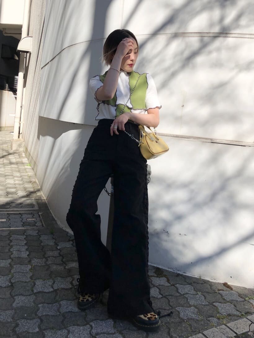 イエロー系のボストンバッグ、ブラック系のデニムパンツ、グリーン系のTシャツ/カットソーを着用したレディースの夏コーディネートの2枚目の写真
