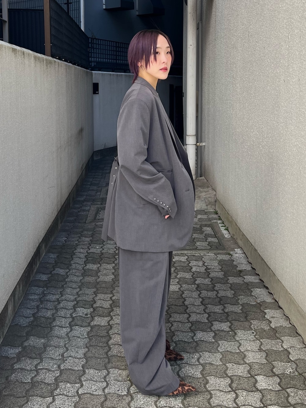 グレー系のテーラードジャケット、グレー系のスラックス、ブルー系のTシャツ/カットソーを着用したレディースの春コーディネートの2枚目の写真