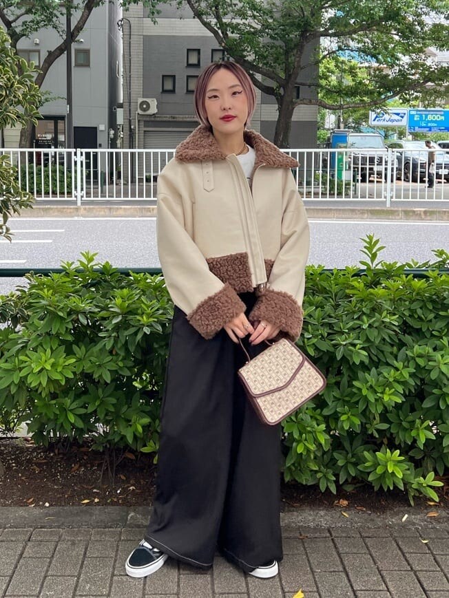 ブラウン系のハンドバッグ、ホワイト系のTシャツ/カットソー、ブラック系のその他パンツを着用したレディースの秋コーディネートの2枚目の写真